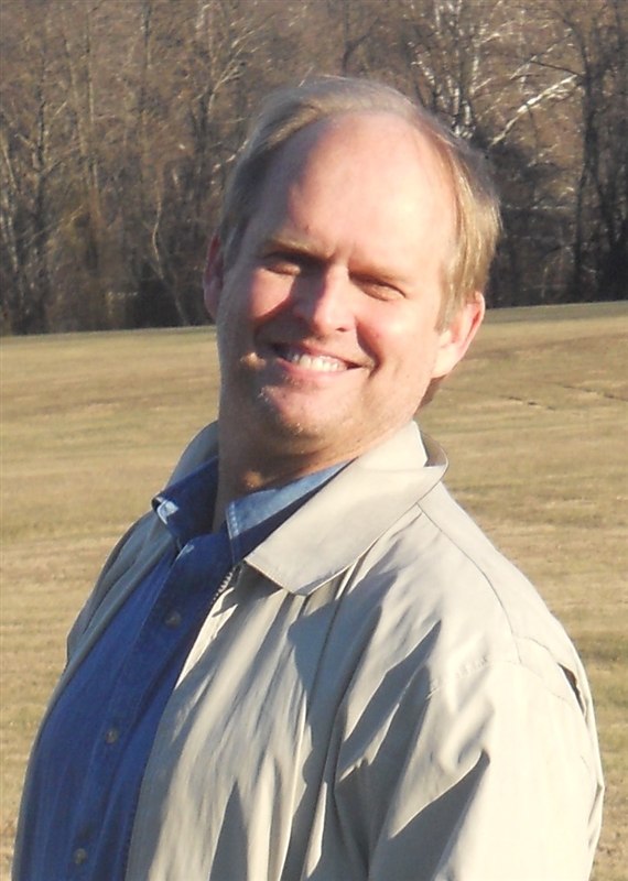 Robin Hanson standing in a field
